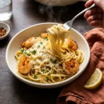 Overhead flat lay of ingredients for creamy garlic shrimp pasta including shrimp, linguine, garlic, butter, cream, parmesan, parsley and lemon