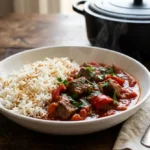 Bowl of Lebanese beef stew with tender beef and red bell pepper beside fluffy vermicelli rice with parsley