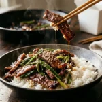 Mongolian beef with crispy-edged beef strips in a glossy dark sauce and green onions over white rice